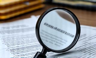 A magnifying glass over a personal file.